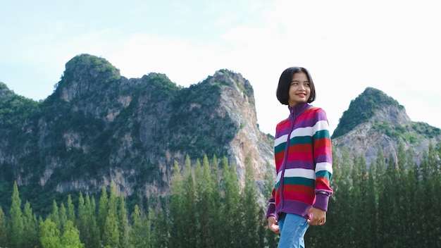 Jovem feliz usar camisola em pé com bela vista da paisagem.