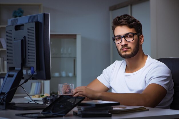 Foto jovem fica até tarde no escritório para fazer horas extras