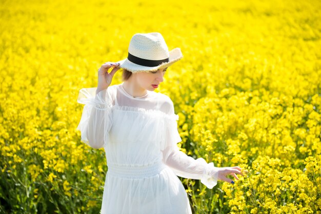 Jovem fica em um campo amarelo