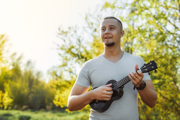 Foto jovem fica tocando ukulele no parque