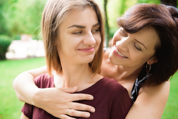 Jovem filha abraçando a mãe com amor.