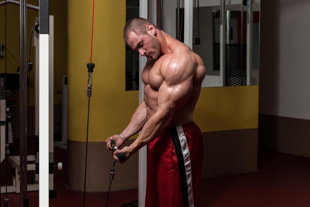 Jovem fisiculturista fazendo exercícios de peso pesado para bíceps