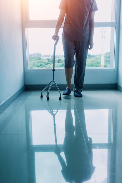 Jovem fisioterapeuta asiática trabalhando com mulher sênior andando com um andador