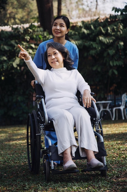 Jovem fisioterapeuta asiática trabalhando com mulher sênior andando com um andador