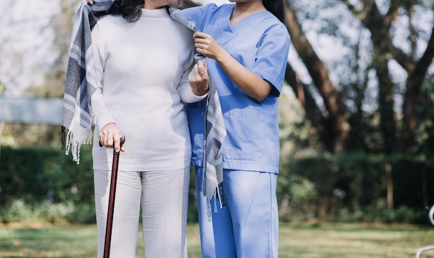 Jovem fisioterapeuta asiático trabalhando com uma mulher idosa em caminhar com um andador