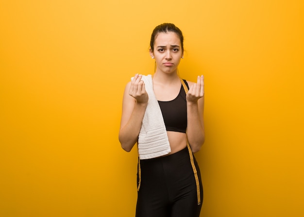 Jovem fitness fazendo um gesto de necessidade