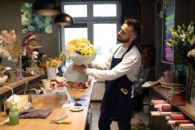 Jovem florista masculina escolhendo um buquê