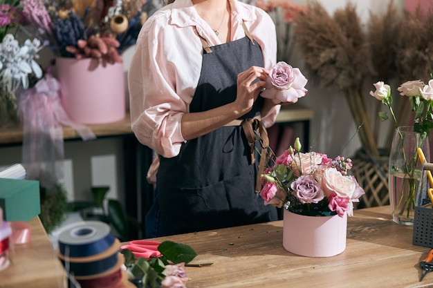 Jovem florista profissional fazendo buquês em uma floricultura