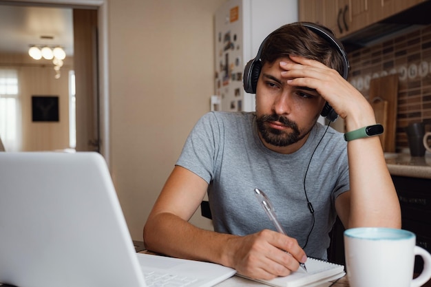 Jovem focado usa fones de ouvido estudam online