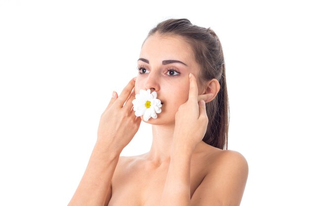 Jovem fofa cuida de sua pele com flor branca