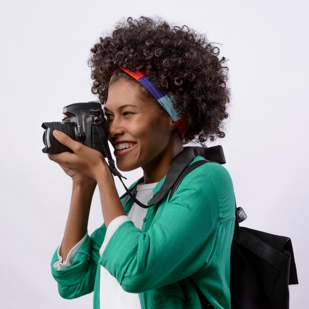 Foto jovem fotógrafa negra com câmera fotográfica de cabelo encaracolado de poder preto em fundo branco