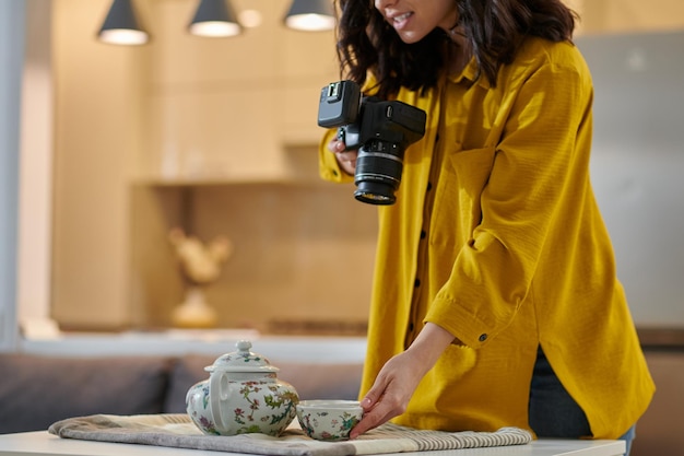 Jovem fotógrafo feminino com câmera nas mãos