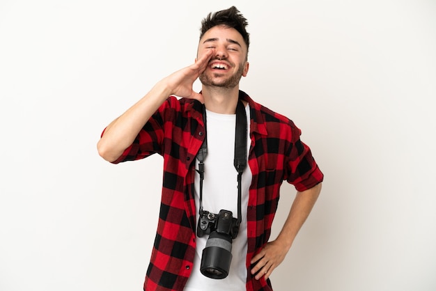 Jovem fotógrafo homem caucasiano isolado no fundo branco gritando com a boca bem aberta