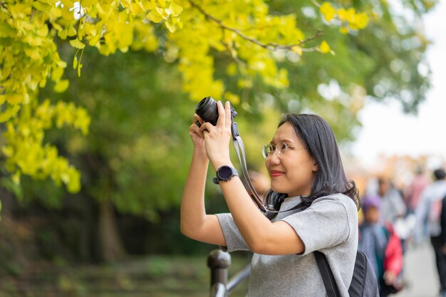 Jovem fotógrafo lindo com a câmera profissional tirando foto