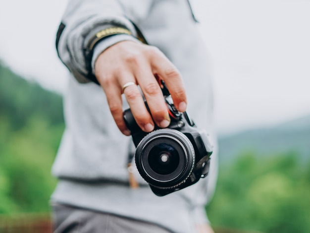 Jovem fotógrafo masculino segurando uma câmera