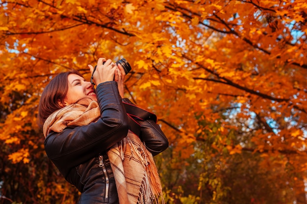 Jovem fotógrafo tira fotos da floresta de outono