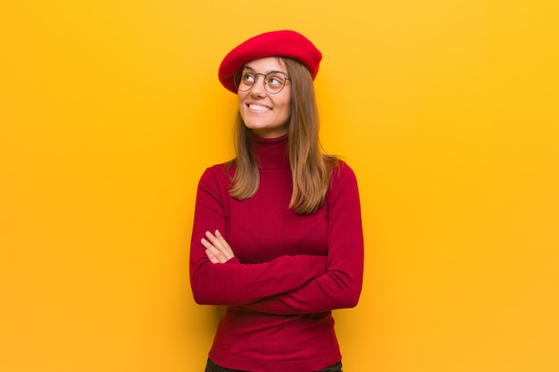 Jovem, francês, artista, mulher sorri, confiante, e, cruzando braços, olhar