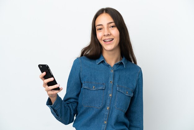 Jovem francesa isolada em um fundo branco usando um telefone celular