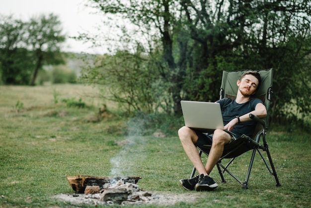 Jovem freelancer relaxando na floresta