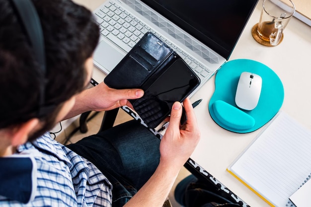 Jovem freelancer sorridente lendo a mensagem em seu telefone