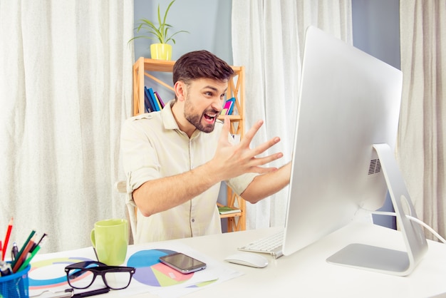 Jovem furioso gritando para o computador