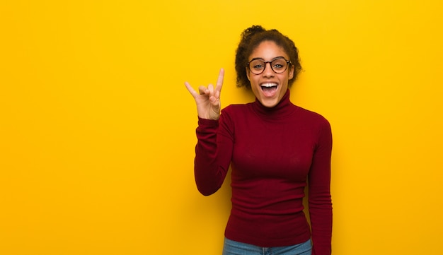 Jovem garota afro-americana negra com olhos azuis, fazendo um gesto de pedra