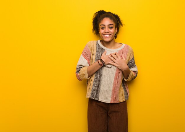 Jovem garota afro-americana negra com olhos azuis, fazendo um gesto romântico