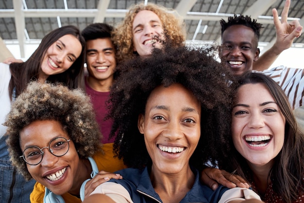 Foto jovem garota afro-americana tira uma foto de celular com seu grupo multirracial de amigos