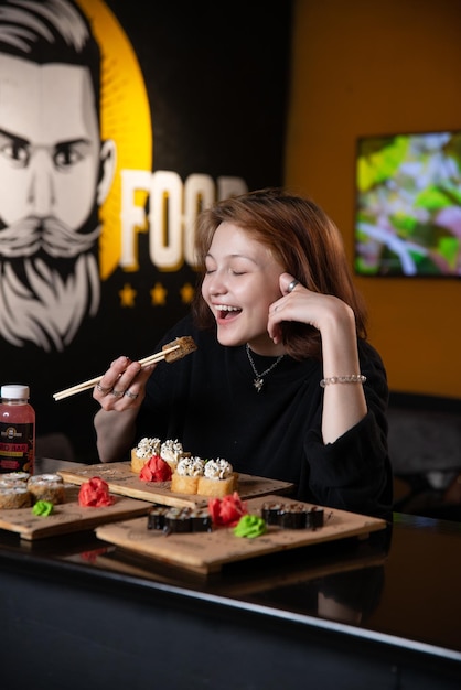 Foto jovem garota asiática come sushi