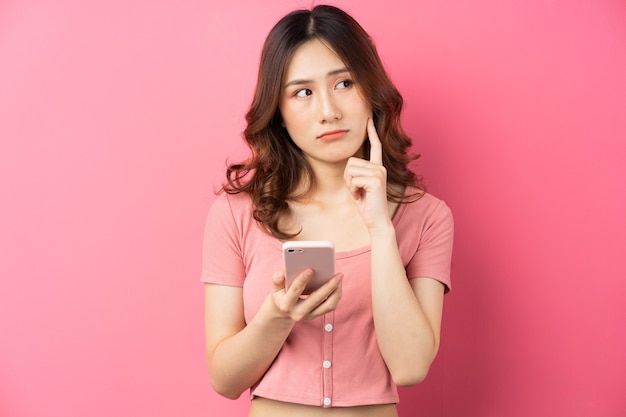 Jovem garota asiática usando o telefone rosa