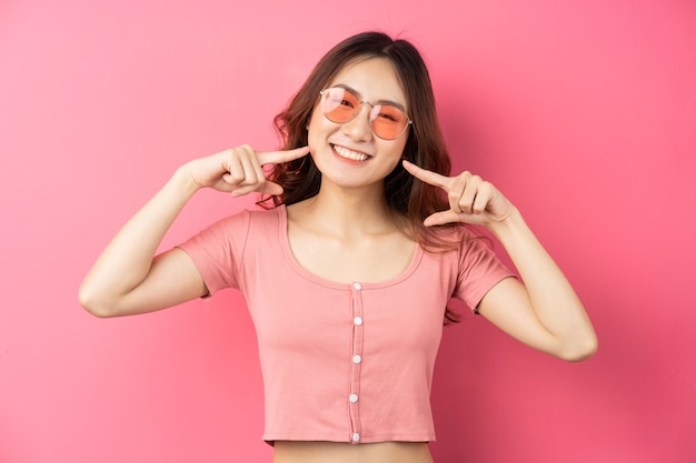 Jovem garota asiática usando óculos com uma expressão alegre em uma rosa