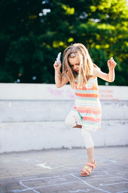 Jovem garota brincando em um bairro urbano no verão