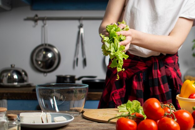 Jovem garota está preparando uma salada