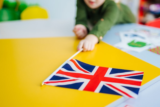 Jovem garota está segurando a bandeira Union Jack. Bandeira britânica na vista frontal.