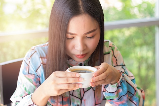 Jovem garota está tomando café na cafeteria