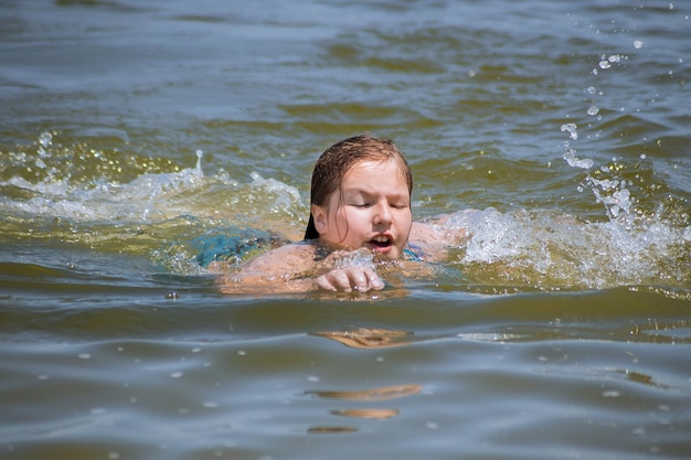 Jovem garota nadando no oceano com os olhos fechados conceito de férias