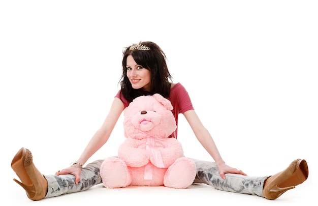 Jovem garota sexy senta-se com um ursinho de pelúcia isolado no fundo branco