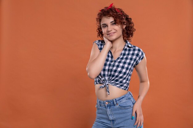 Foto jovem garota vestida em estilo pin up com cabelos encaracolados de cor castanha