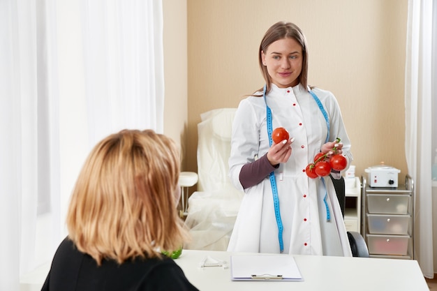 Jovem garota visitando nutricionista para perder peso com a ajuda do programa de dieta.