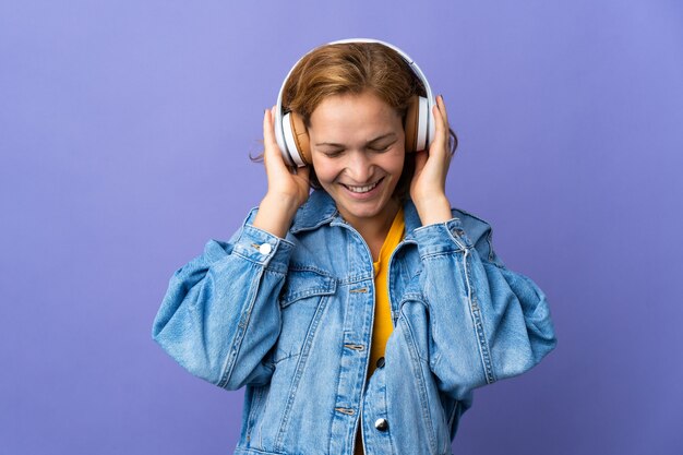 Jovem georgiana isolada em um fundo roxo ouvindo música