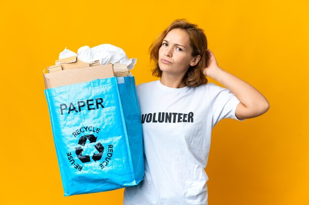 Jovem georgiana segurando uma sacola cheia de papel para reciclar, tendo dúvidas