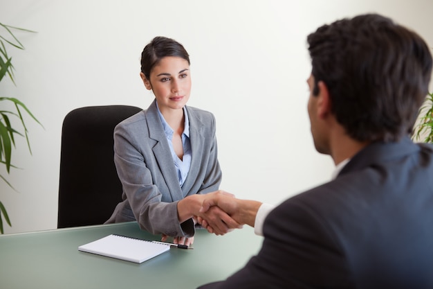 Jovem gerente agitando a mão de um cliente