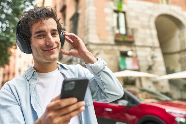 Jovem gosta da conveniência da música móvel usando fones de ouvido