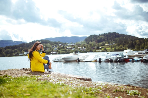 Jovem goza de liberdade contra o pano de fundo das montanhas na Noruega A garota turista