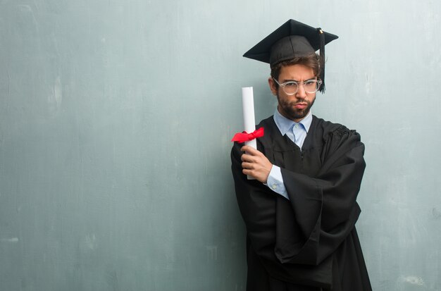 Jovem, graduado, homem, contra, um, grunge, parede, com, um, cópia, espaço, muito, zangado, e, chateado