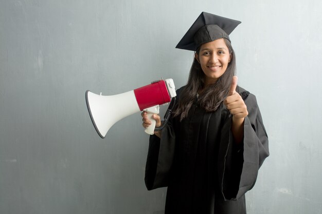 Jovem, graduado, indianas, mulher, contra, um, parede, alegre, e, excitado, sorrindo, e, levantando, dela