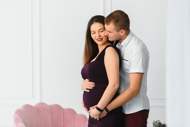 Jovem grávida com marido a posar