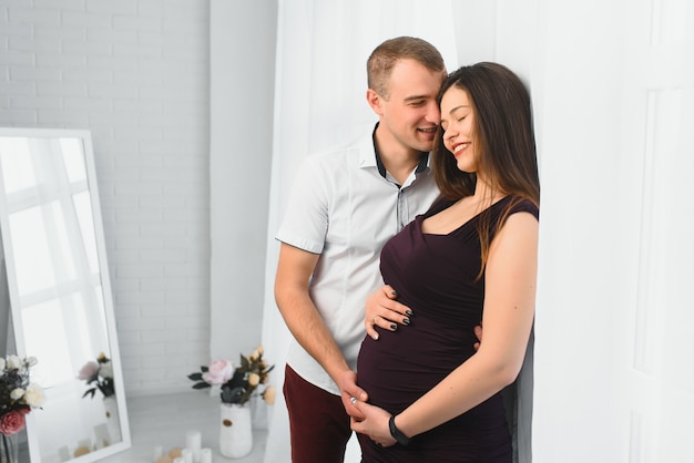 Jovem grávida com marido a posar