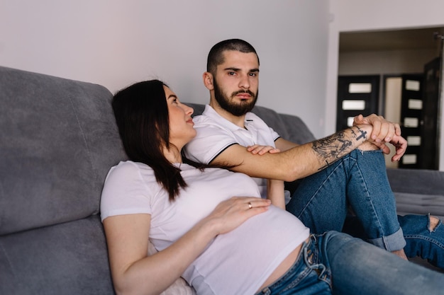 Jovem grávida com o marido em casa