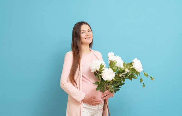 Jovem grávida com um buquê de flores